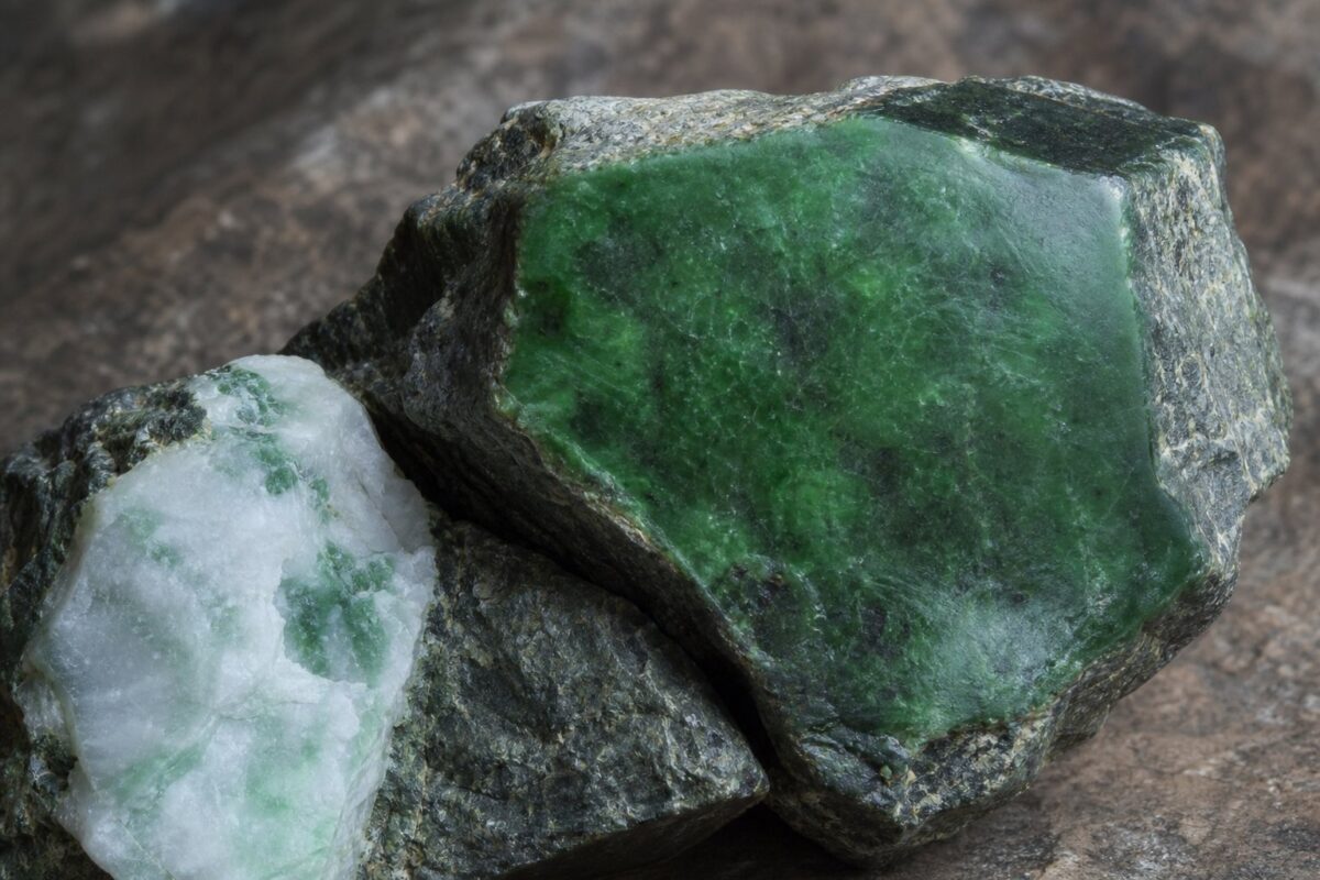 Rå grøn nefrit-jade med poleret flade ved siden af hvid jadeit med grønne årer i serpentinit